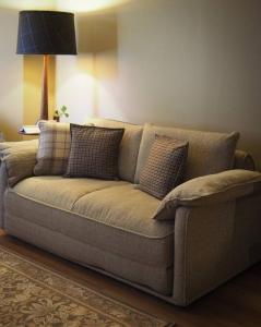 a brown couch with pillows in a living room at Charlie on Charlick - Fully Renovated 1BR Apt in Adelaide