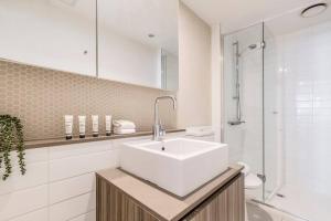 uma casa de banho branca com um lavatório e um chuveiro em Central Charm Small Studio Retreat in Melbourne em Melbourne