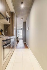 uma cozinha com um piso branco e um longo corredor em Central Charm Small Studio Retreat in Melbourne em Melbourne