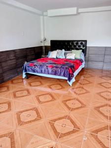 1 dormitorio con 1 cama y suelo de madera en Studio Luna, en Pereira