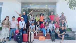un gruppo di persone che posano per una foto con i bagagli di Hải Long Hotel Đảo Phú Quý a Cu Lao Thu