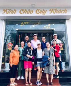 un gruppo di persone che si trovano sui gradini di fronte a un negozio di Hải Long Hotel Đảo Phú Quý a Cu Lao Thu