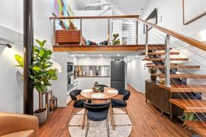 um quarto com uma mesa e cadeiras e uma escada em Woolstore Elegance ~ 2Bed/2Bath/1Car ~ Teneriffe em Brisbane