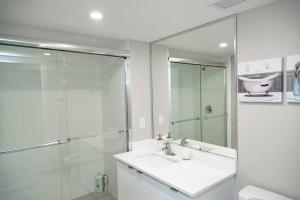 La salle de bains est pourvue d'un lavabo et d'une douche en verre. dans l'établissement Charm & Luxury Vacation Headquarters to Downtown!, à Montréal