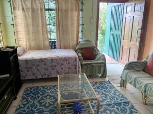 a room with a bed and a couch and a table at Elizabeth Accomodation-Your Home Away from Home in Suva