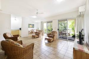 a living room with couches and chairs and a television at Vintage Charm at The Gardens with Lagoon Pool in Stuart Park