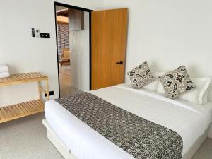 a bedroom with a white bed with pillows at Arau House in Arau
