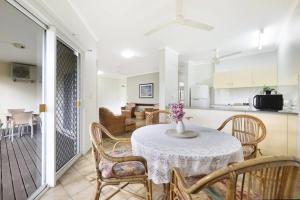 a dining room table with chairs and a kitchen at Vintage Charm at The Gardens with Lagoon Pool in Stuart Park