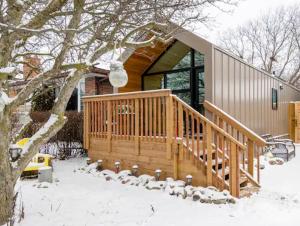a group of sheep standing outside of a house in the snow at Tiny House Haven in Peterborough