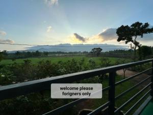a sign on a fence with a field in the background at Ridge Boundary View in Dambulla