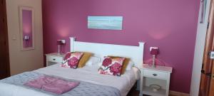 una camera da letto con un letto bianco e pareti viola di Casa Roble B&B a Cómpeta