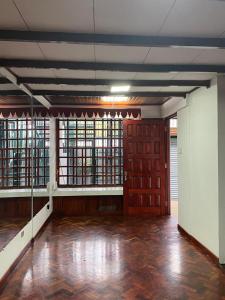 ein leeres Zimmer mit Holzböden, Türen und Fenstern in der Unterkunft CasaZheng in San José