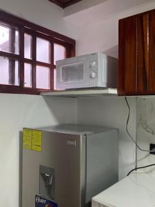 a microwave on top of a refrigerator in a kitchen at CasaZheng in San José