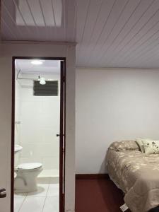 a bedroom with a bed and a bathroom with a toilet at CasaZheng in San José