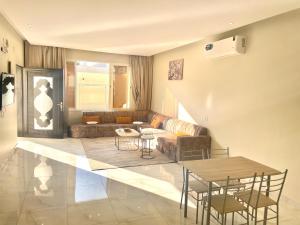 a living room with a couch and a table and chairs at سحاب تهلل السودة Sahab AL-Sodah in Suda