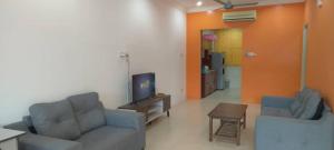 a living room with a couch and a tv and a table at Moyan Square By Natol Homestay in Kuching