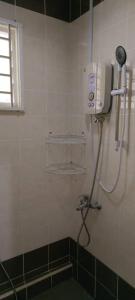 a shower in a bathroom with a phone on the wall at Moyan Square By Natol Homestay in Kuching