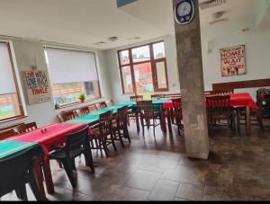 a restaurant with tables and chairs and a clock on the wall at Shekerdejiiski guest house bansko in Bansko