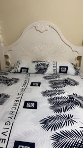 PINEVALLEY APT.SUITE 3A : سرير أبيض مع ملاءات ووسائد سوداء وبيضاء