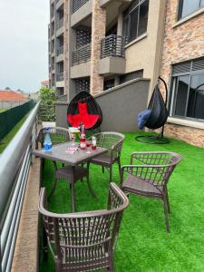 een patio met een tafel en stoelen op een balkon bij Heavenly Getaways, Nalya in Kampala