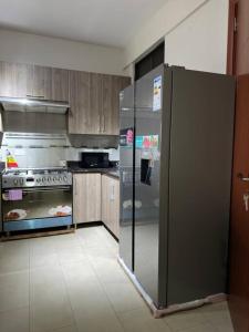 een keuken met een roestvrijstalen koelkast bij Heavenly Getaways, Nalya in Kampala