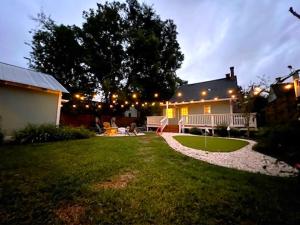 a backyard at night with a house with lights at The Auggie Historic Home with putting green in Saint Augustine