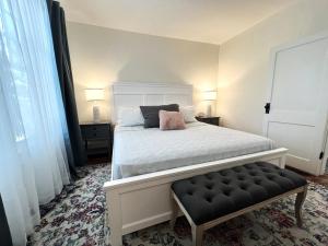 a bedroom with a white bed with a pink pillow at The Auggie Historic Home with putting green in Saint Augustine