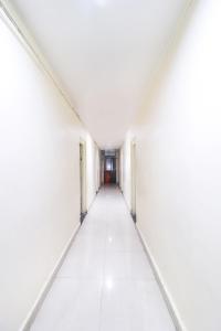 un pasillo vacío en un edificio blanco vacío en Collection O Aaradhna Lodge, en Alandi