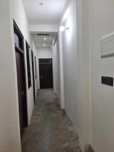 AyodhyaにあるHotel O Home Sita Ram Palaceの白壁と黒い扉の長い廊下 +8枚の写真