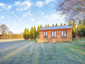 a small wooden house on a grass field at Kestrel Lodge in Little Witley