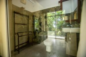 a bathroom with a toilet and a sink and a window at Evergreen Hotel Dambulla in Dambulla