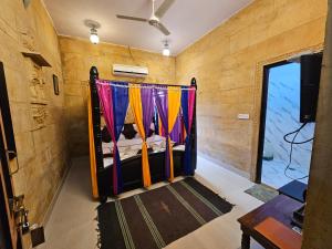 a bedroom with a bed with colorful curtains at Hotel Royal Haveli in Jaisalmer