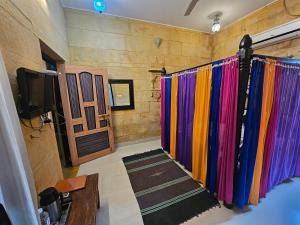 a room with colorful shower curtains and a television at Hotel Royal Haveli in Jaisalmer