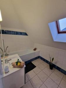 uma casa de banho com um lavatório e uma banheira em Appartement la marine em Saint-Leu