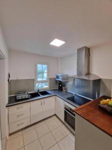 a kitchen with stainless steel appliances and a counter at Appartement la marine in Saint-Leu