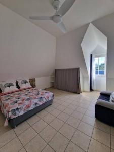 una camera con un letto e un divano di Appartement la marine a Saint-Leu