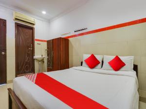 a bedroom with a large bed with red pillows at OYO 82071 HOTEL SITA Grand in Shamshabad