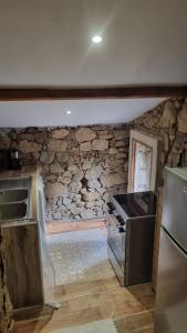 a kitchen with a stone wall and a stove at Langhjuledda in Grosseto-Prugna