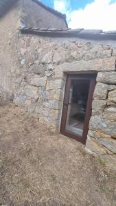 een deur in een stenen gebouw met een raam bij Langhjuledda in Grosseto-Prugna
