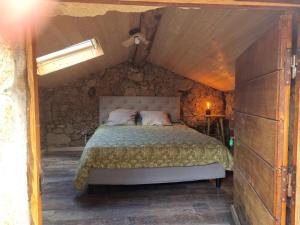 a bedroom with a bed in a stone wall at Langhjuledda in Grosseto-Prugna
