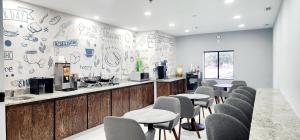 un restaurant avec des chaises et un bar avec des graffitis sur le mur dans l'établissement Baymont by Wyndham Port Wentworth, à Port Wentworth