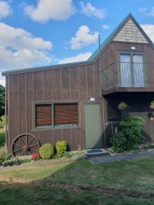 ein großes Holzhaus mit einem Balkon und einem Rad in der Unterkunft Mangaroa, farmstay in Upper Hutt