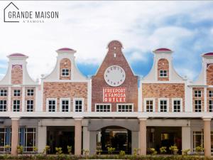 a building with a clock on the front of it at GRANDE MAISON HOMES 2 A'Famosa Golf view Near WATERPARK l UITM l HONDA l Netflix l Self Check in in Kampong Alor Gajah