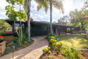 una casa con palmeras y un camino de entrada en Tropical, Private, Heated pool, Petting zoo!, en Vista