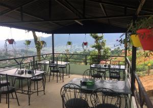 un grupo de mesas y sillas en un balcón con vistas en Kankali Viewpoint Resort Pvt Ltd, en Katmandú