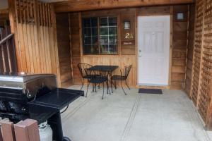 eine Terrasse mit einem Tisch, Stühlen und einer Tür in der Unterkunft Timber Creek Chalets- 2A chalet in Estes Park