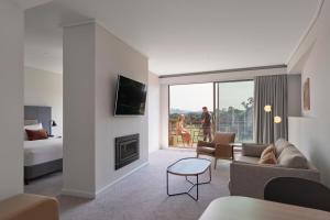 a living room with a bed and a living room with a fireplace at RACV Goldfields Resort in Ballarat