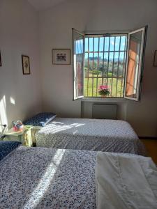 2 camas en una habitación con ventana en Poggio agli Ulivi, en Frascati