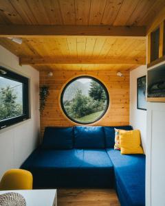 un divano blu in una stanza con finestra di Togethernest Glamping a Mătişeşti