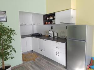 a kitchen with white cabinets and a refrigerator at Апартамент Рая 2 in Dobrich